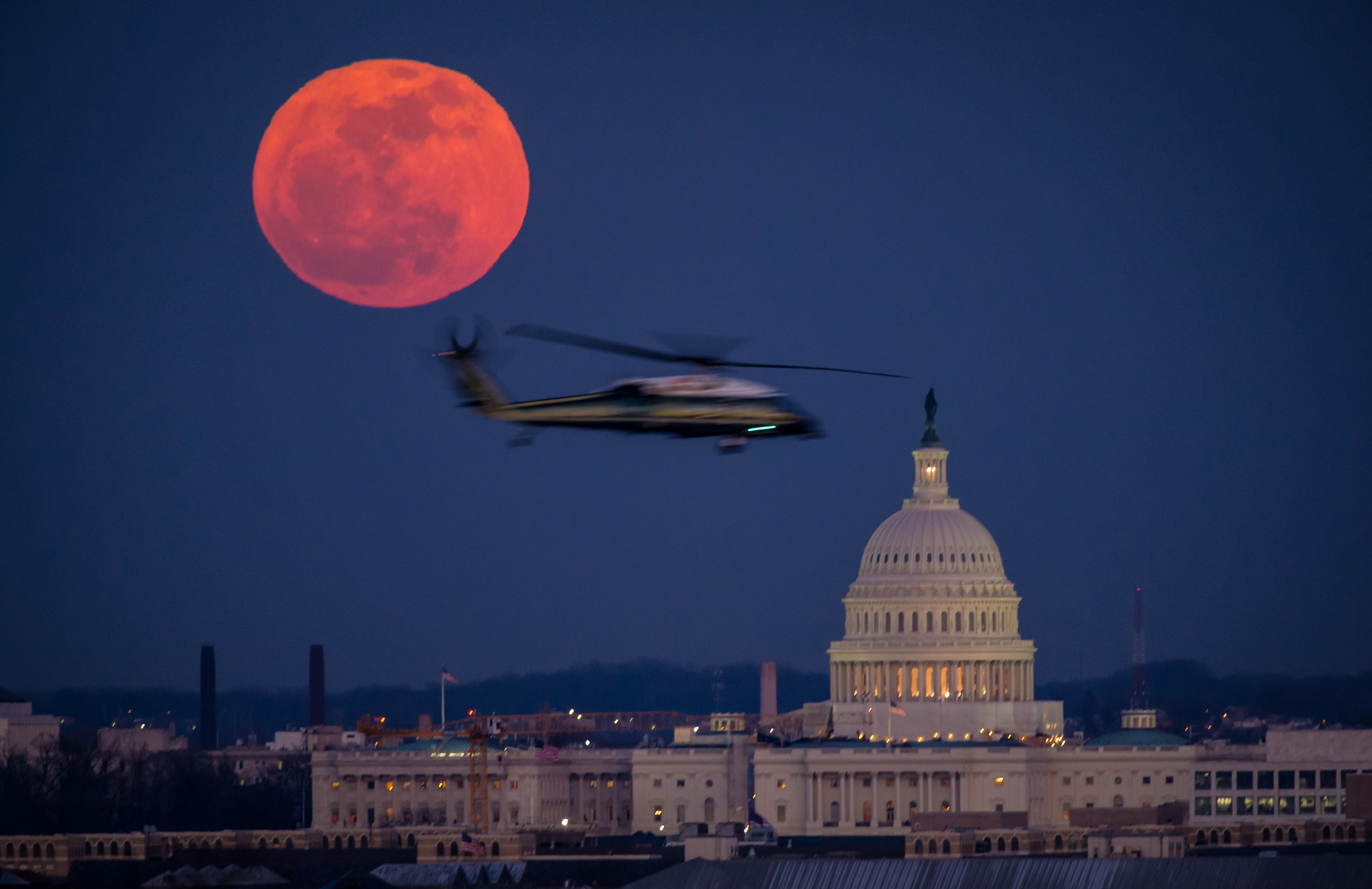 شوهدت طائرة هليكوبتر تابعة لقوات مشاة البحرية الأمريكية تحلق عبر هذا المشهد من اكتمال القمر ومبنى الكابيتول الأمريكي يوم الثلاثاء ، 7 فبراير ، 2012 من مقبرة أرلينغتون الوطنية