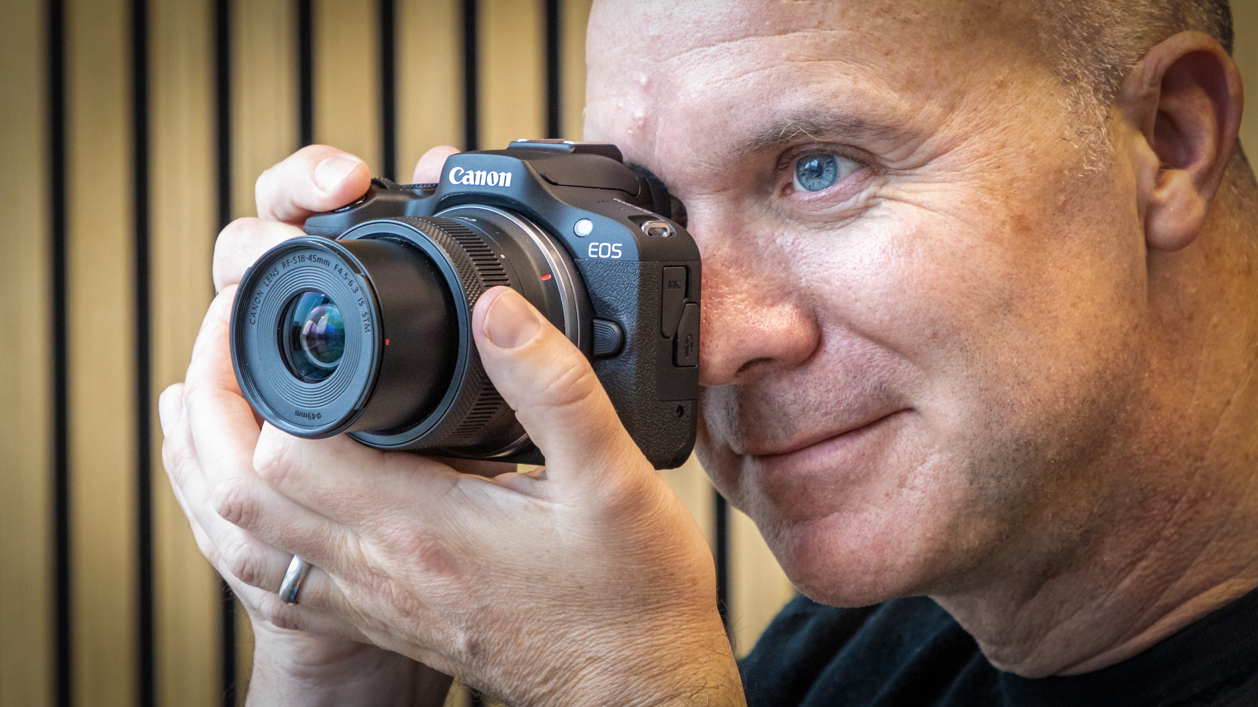 بيتر ترافرز يحمل كاميرا Canon EOS R100