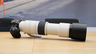عدسة Canon RF 200-800mm f/6.3-9 IS USM على كاميرا Canon EOS R5 على طاولة خشبية