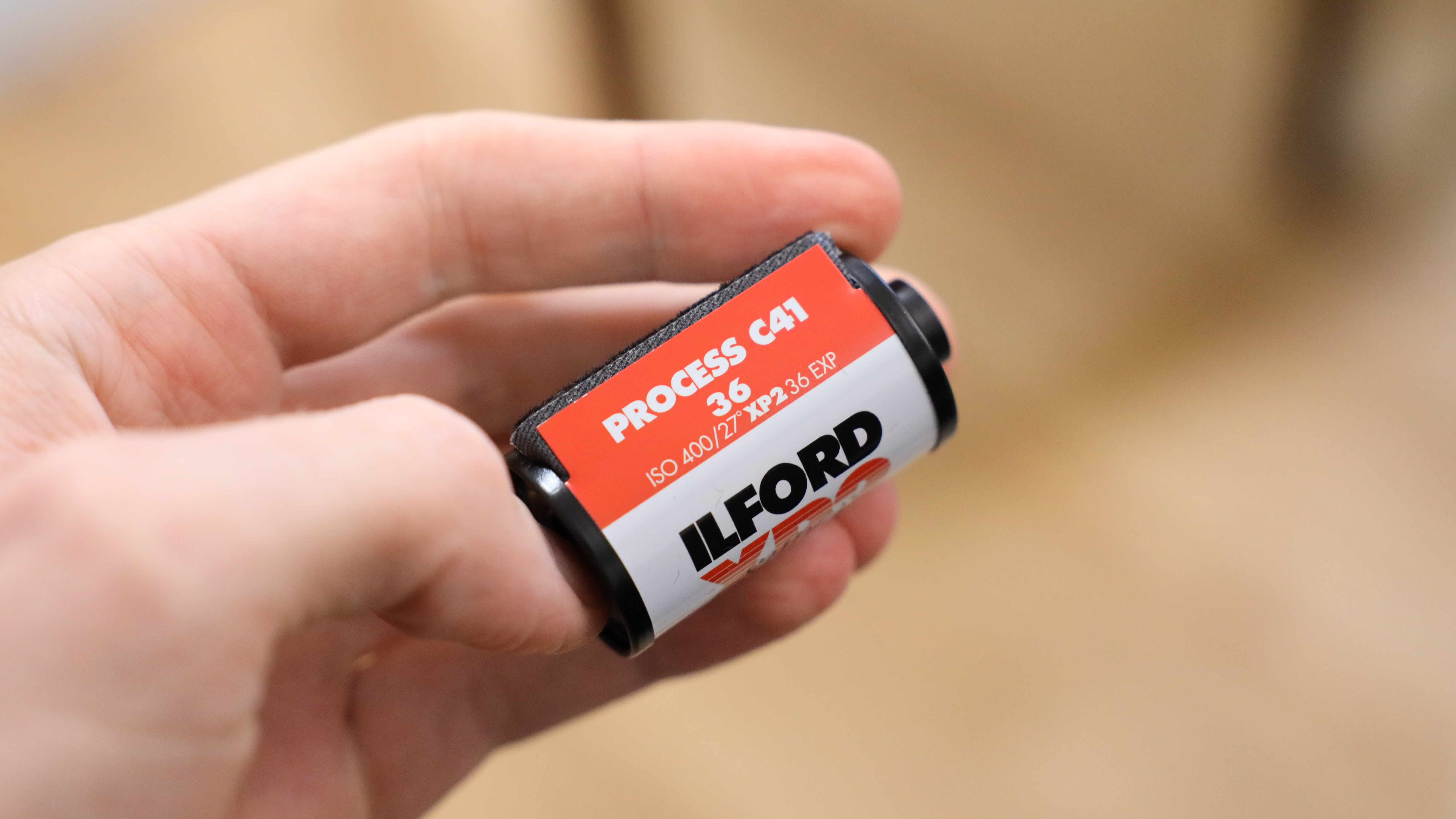 علبة فيلم Ilford XP2 Super 35mm ممسوكة في اليد