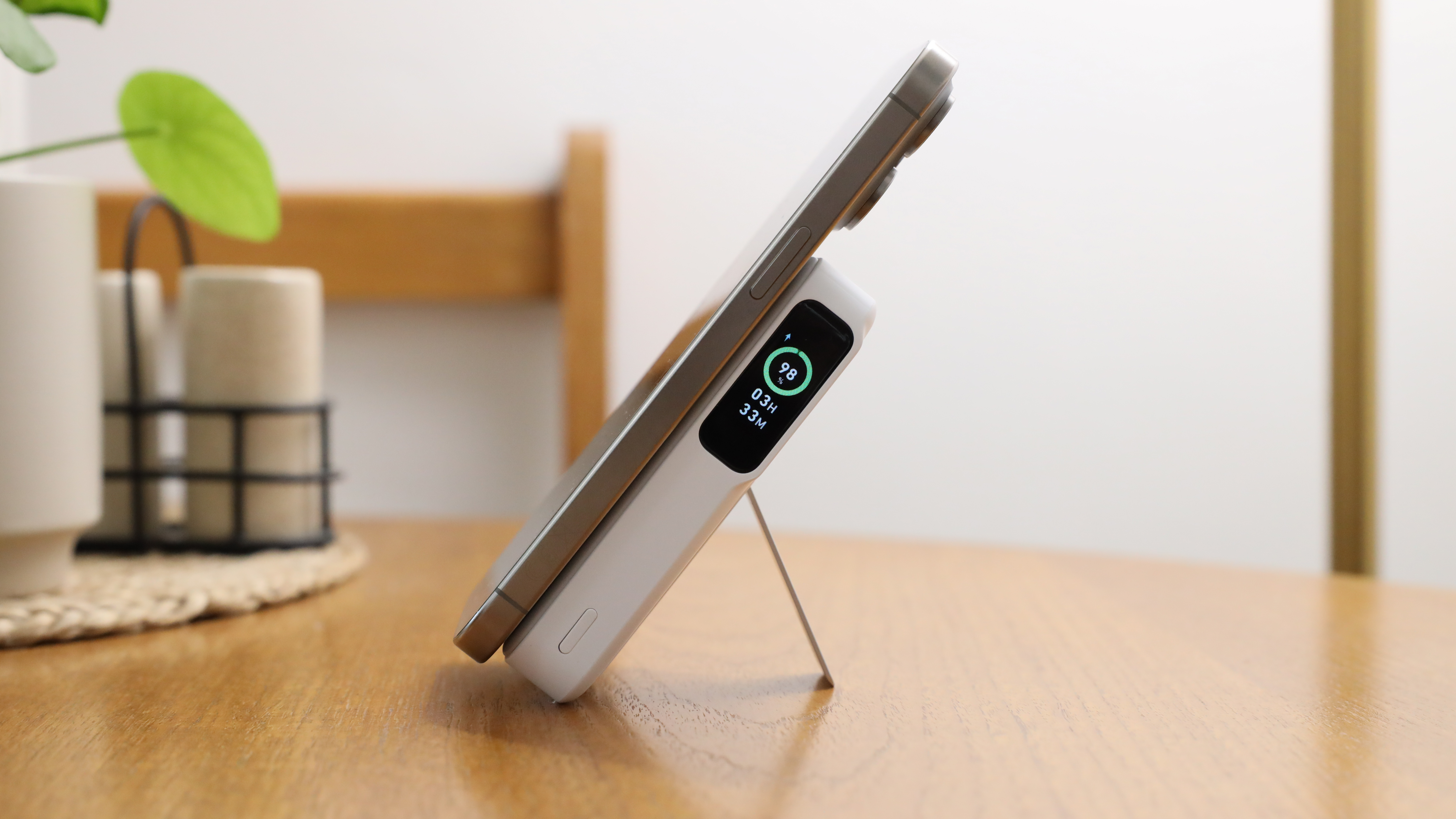 باور بانك Anker MagGo (10K) متصل بجهاز iPhone 15 Pro Max على طاولة خشبية